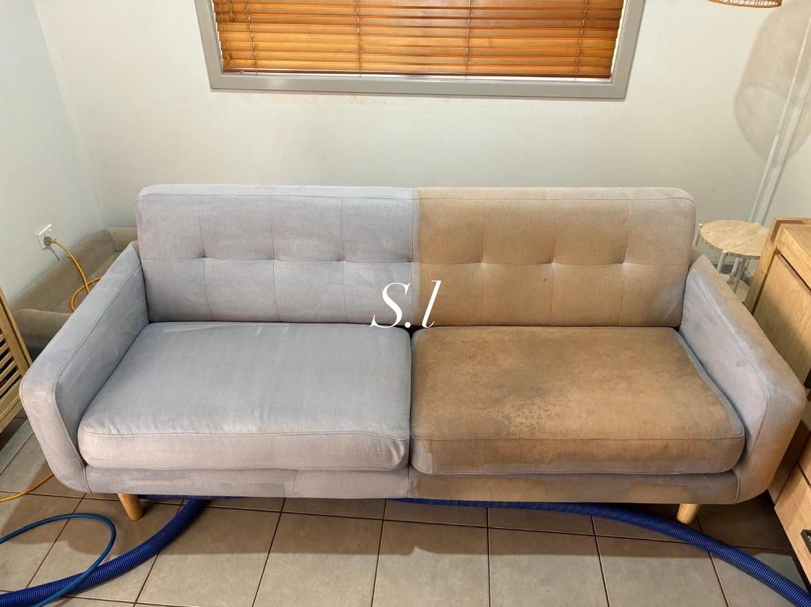 A lounge caught halfway through steam cleaning, one half clean and one half still stained